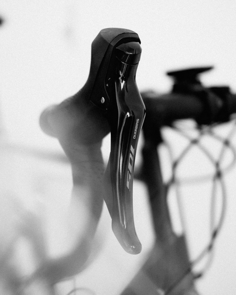 Gros plan en noir et blanc sur un levier de vitesse de vélo de route